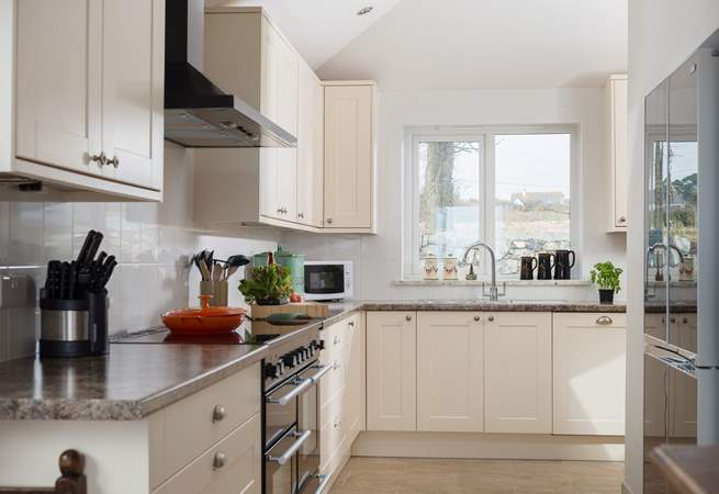 A modern and well-equipped kitchen including a range cooker and a large fridge/freezer.