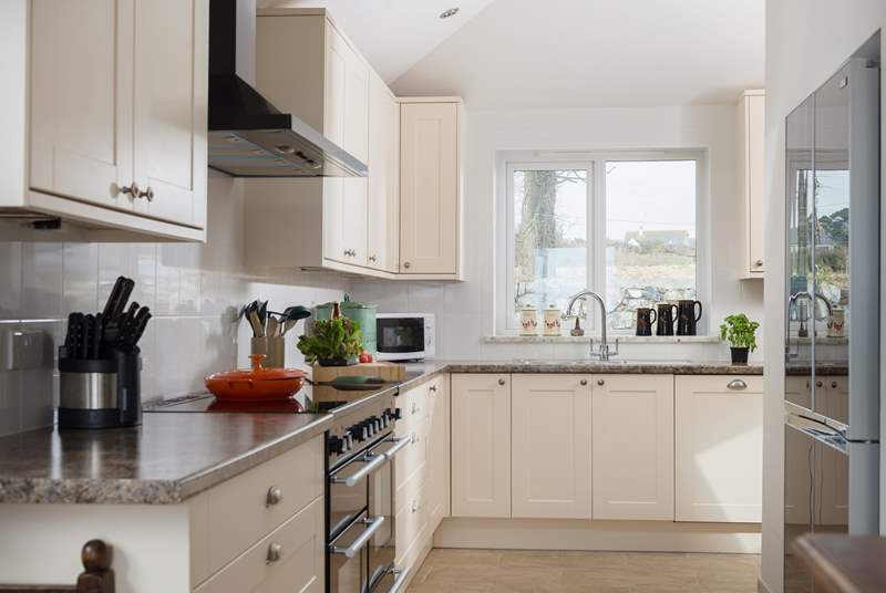 A modern and well-equipped kitchen including a range cooker and a large fridge/freezer.