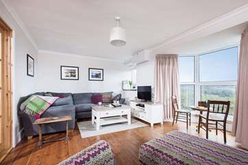 The living-room is perfectly furnished for relaxing with a stylish and comfy corner sofa and armchair.