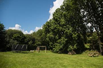 Dotted along the river's edge (which is fenced for safety) are picnic benches, a lovely firepit and a trampoline, shared by all.