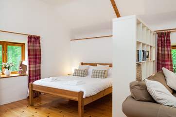There is a bookcase which separates the bed from the living area.