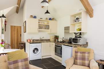 There is a kitchen tucked into one corner of the open plan living space, well-equipped with all you could need for your stay.