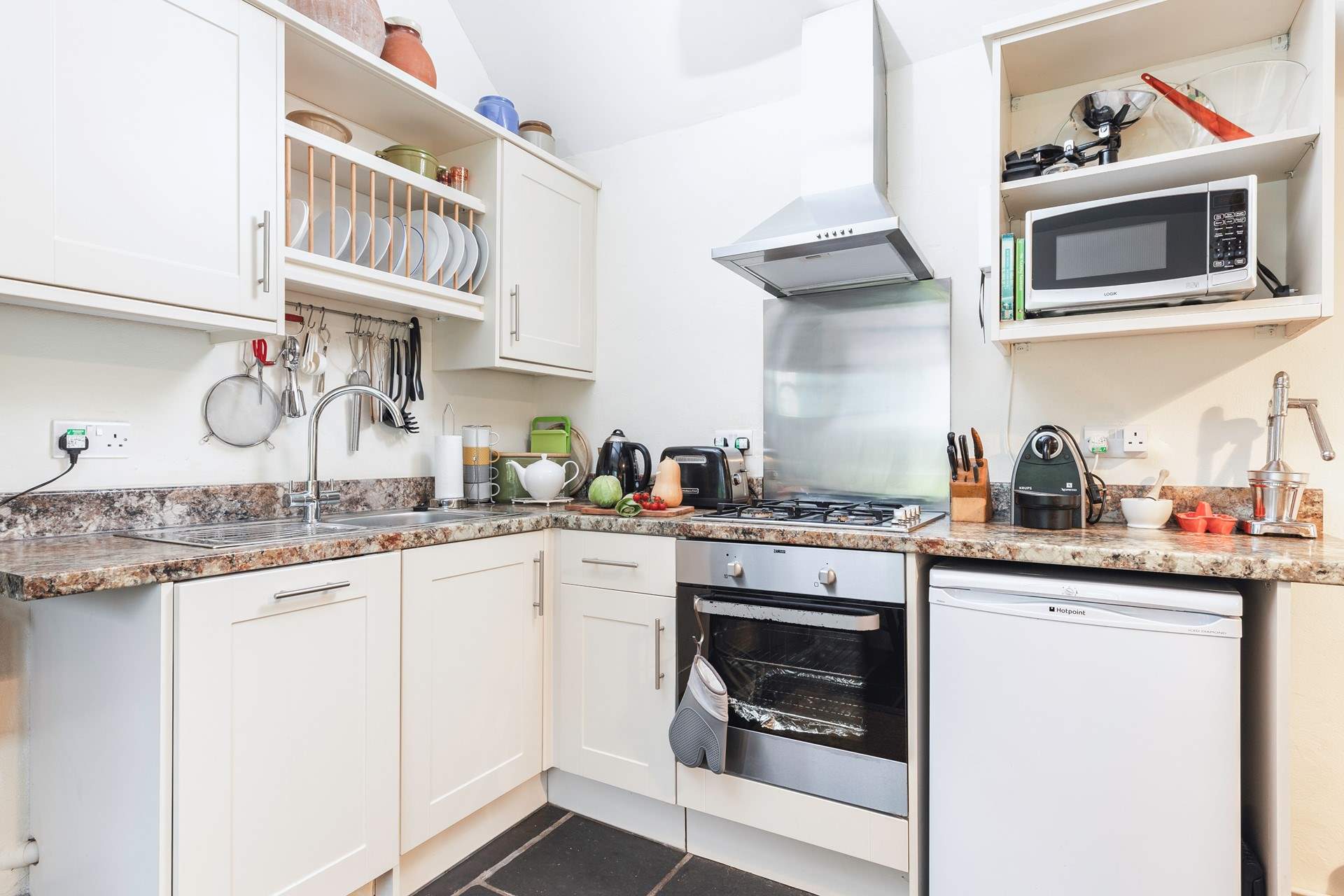 There is a kitchen tucked into one corner of the open plan living space. Please note, the gas hob was replaced with an induction hob in May 2024 (new photos available soon).