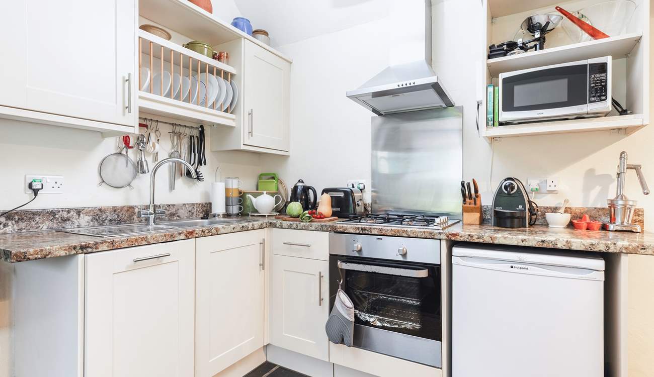 There is a kitchen tucked into one corner of the open plan living space. Please note, the gas hob has been replaced with an induction hob.
