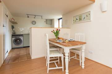 There is a little farmhouse dining-table and the kitchen area is beyond.