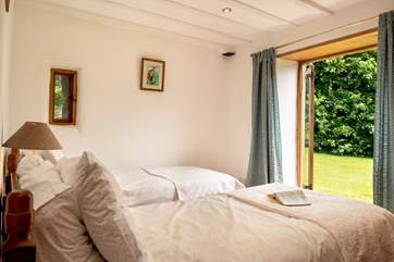 The twin bedroom on the ground floor opens straight into the garden.