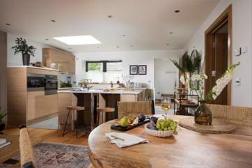 Inside this sweet escape you'll find an open plan kitchen and living space, adorned in a soft palette of pastel hues and rustic interior touches.