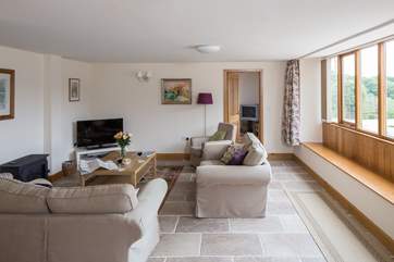 The spacious sitting-room has plenty of comfortable seating. Windows all along one wall face the farm - a great viewing gallery.