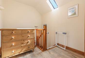 The hallway is bright and spacious, with a stair gate for your peace of mind.