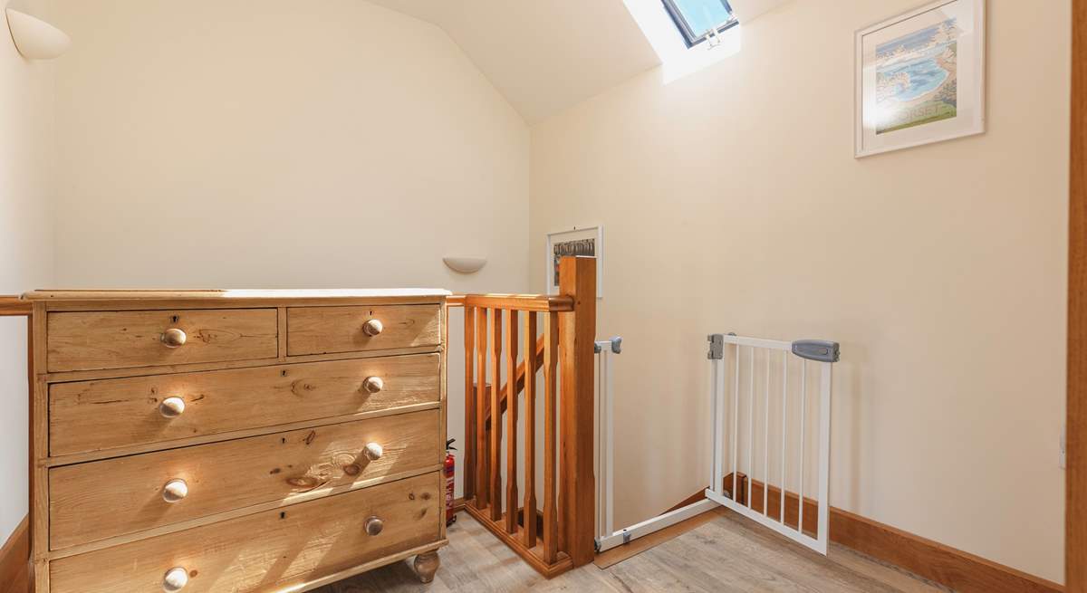 The hallway is bright and spacious, with a stair gate for your peace of mind.