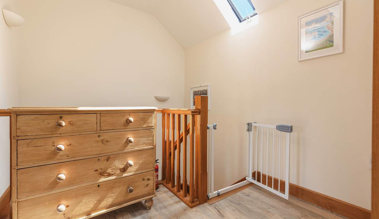 The hallway is bright and spacious, with a stair gate for your peace of mind.