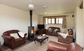 The sitting-room with its wood-burner and deep leather sofas is great for relaxing after a day out exploring. - Thumbnail Image