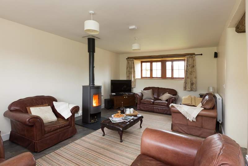 The sitting-room with its wood-burner and deep leather sofas is great for relaxing after a day out exploring.