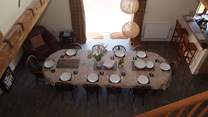 The spacious open plan living-area has the dining-table in the central part, the living-room to the left and the kitchen to the right.