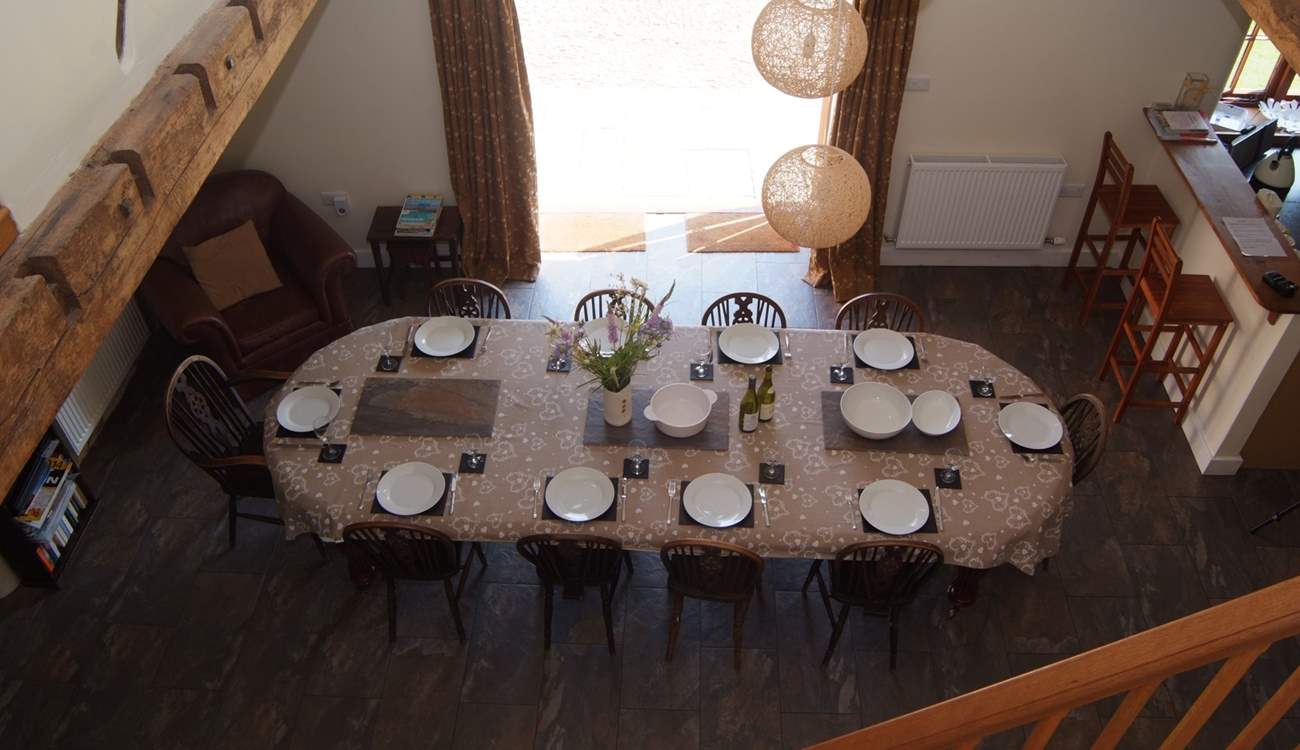 The spacious open plan living-area has the dining-table in the central part, the living-room to the left and the kitchen to the right.