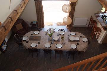 The spacious open plan living-area has the dining-table in the central part, the living-room to the left and the kitchen to the right.