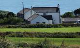 Stargazy Skies is the single-storey cottage in the middle of the picture with two windows. The backdrop of the sea is stunning. - Thumbnail Image