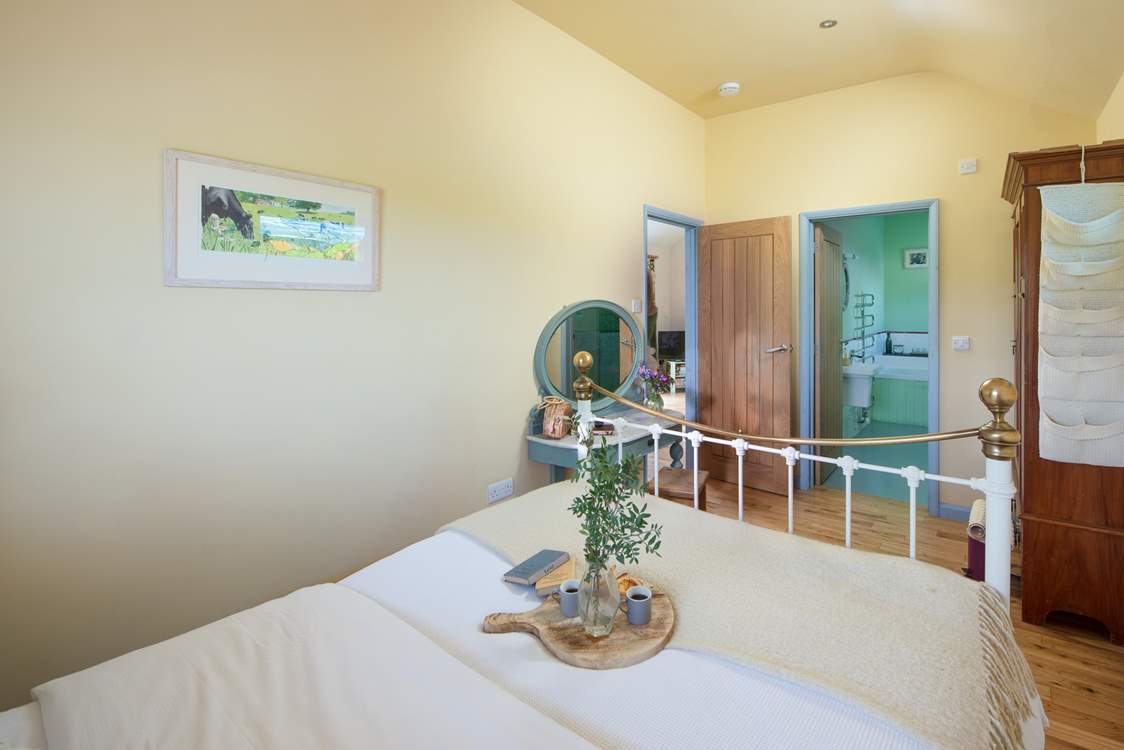 The pretty double bedroom has a feature bedstead.