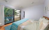 Palm tree fronds give this bedroom a Caribbean vibe. - Thumbnail Image