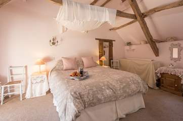 The bedroom is so pretty and inviting.