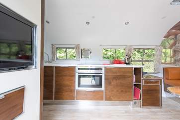 A fully equipped kitchen including dishwasher, oven and induction hob.