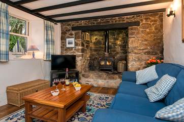 The cosy sitting-room with warming wood-burner in the inglenook fireplace.
