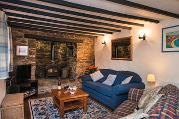 The traditional sitting-room is very cosy with its beamed ceiling and granite inglenook.