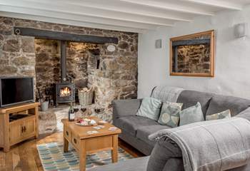 The cosy sitting-room with warming wood-burner in the inglenook fireplace.