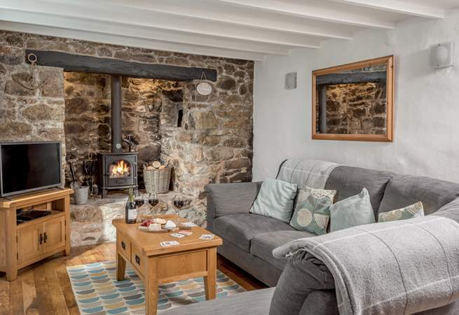 The cosy sitting-room with warming wood-burner in the inglenook fireplace.
