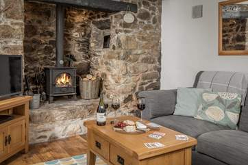 The traditional sitting-room is very cosy with its beamed ceiling and granite inglenook.