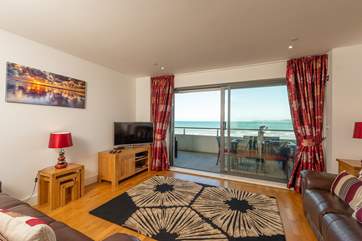 A large open plan living/dining-room, with kitchen at one end opens up onto the wide balcony.