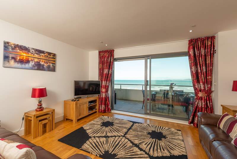 A large open plan living/dining-room, with kitchen at one end opens up onto the wide balcony.