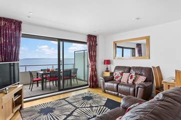 A large open plan living/dining-room, with kitchen at one end opens up onto the wide balcony.