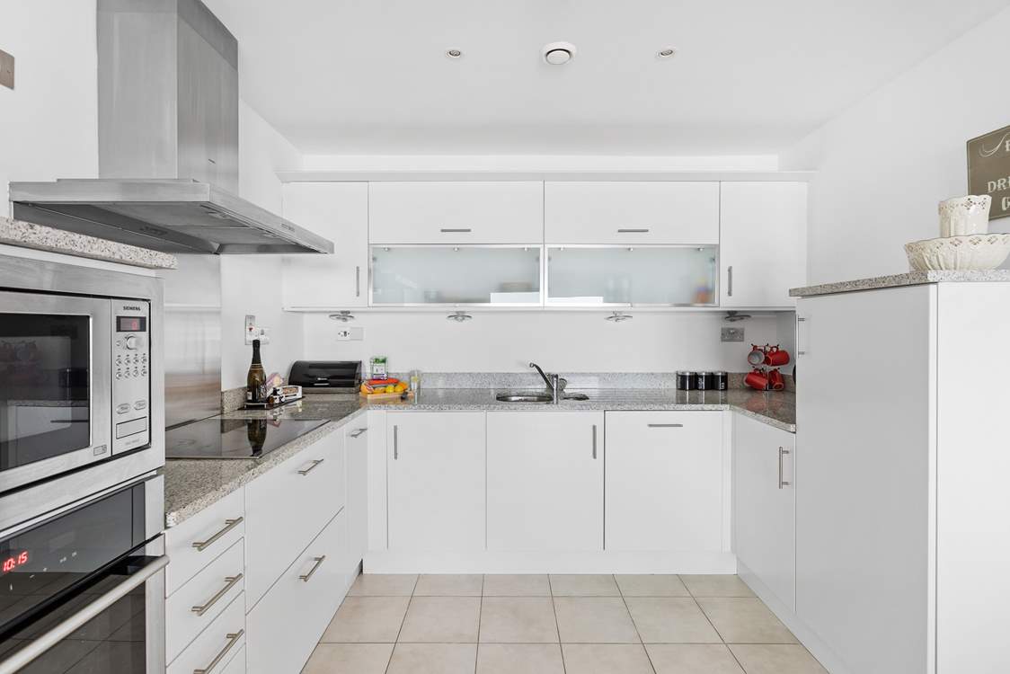 The contemporary kitchen has plenty of storage and there is a very useful separate utility room off it.