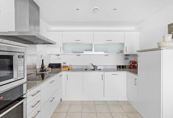 The contemporary kitchen has plenty of storage and there is a very useful separate utility room off it.