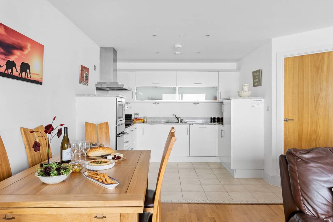 The kitchen is fitted along the back wall of this open plan space.  The utility-room is through the first door on the right.