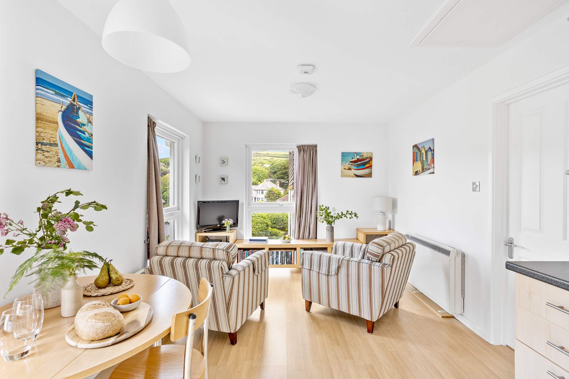 The open plan living-room has two lovely large windows, allowing the light to flood in and for you to admire the view.
