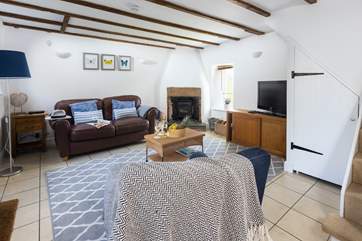 The sitting-room with comfy sofa, chair and the cosy wood-burner.