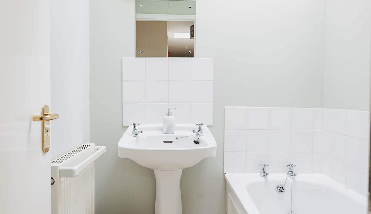 The separate family bathroom is light and cheery, perfect for a soak at the end of the day.