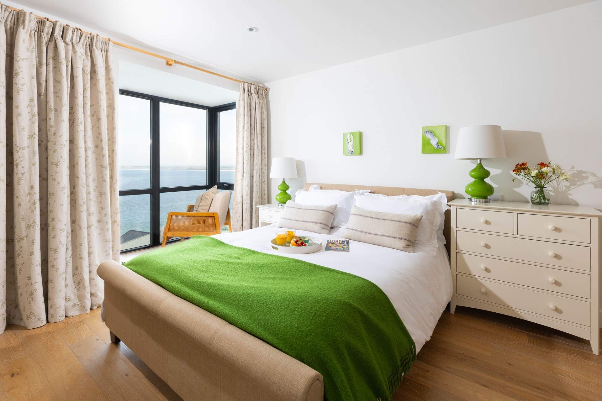 Sweeping views of the sea visible through large floor to ceiling windows in bedroom 1.