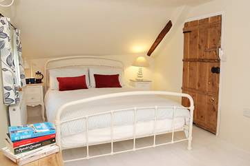 The master bedroom, as with the other bedrooms, has painted floorboards and original cottage doors.