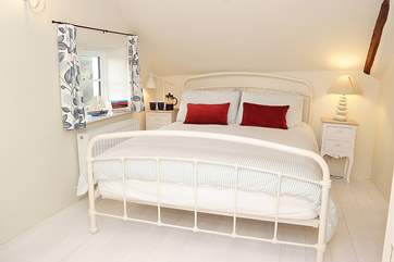 Another view of the master bedroom which has a side window across the lane and the fields, and a front window looking over the garden.