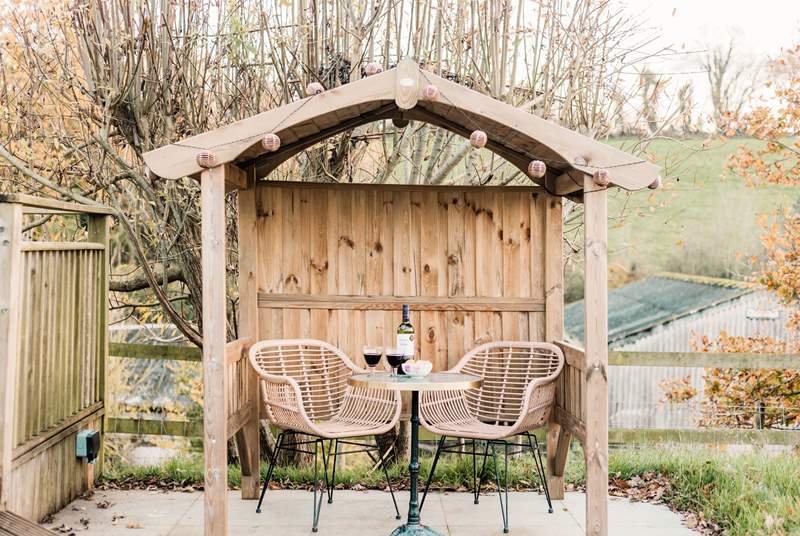 Get cosy in the sweet wooden shelter complete with pretty festoon lighting.