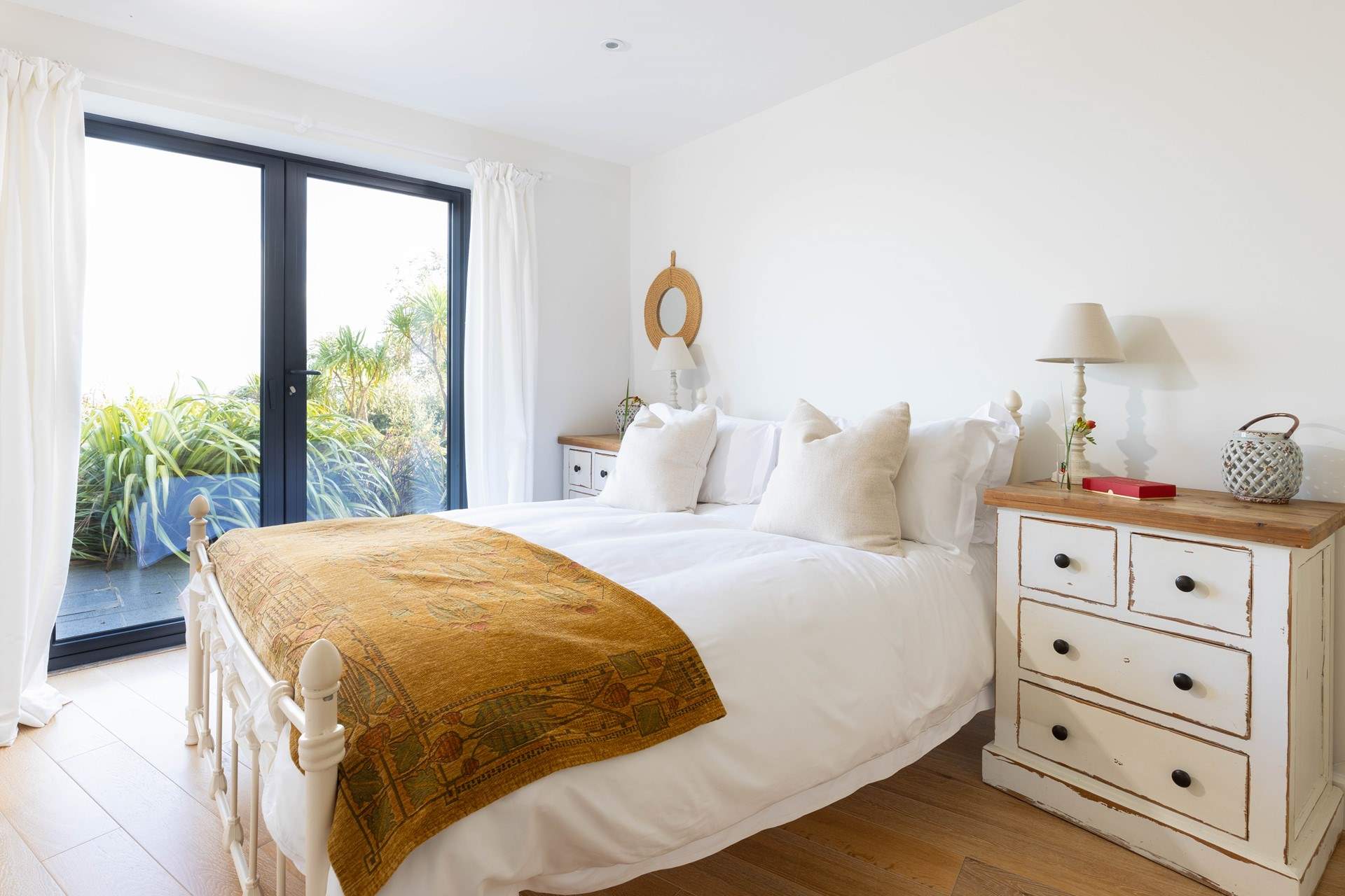 Bedroom 1 has a splendid king-size bed with luxury linens and a view of the surrounding gardens and sea.