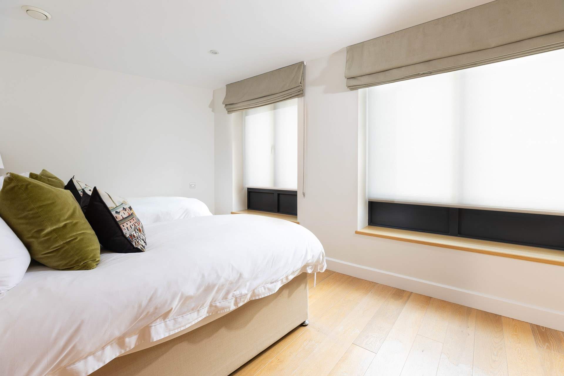 Bedroom 2 is filled with light, this room faces the small private parking area with huge blinds to offer privacy.