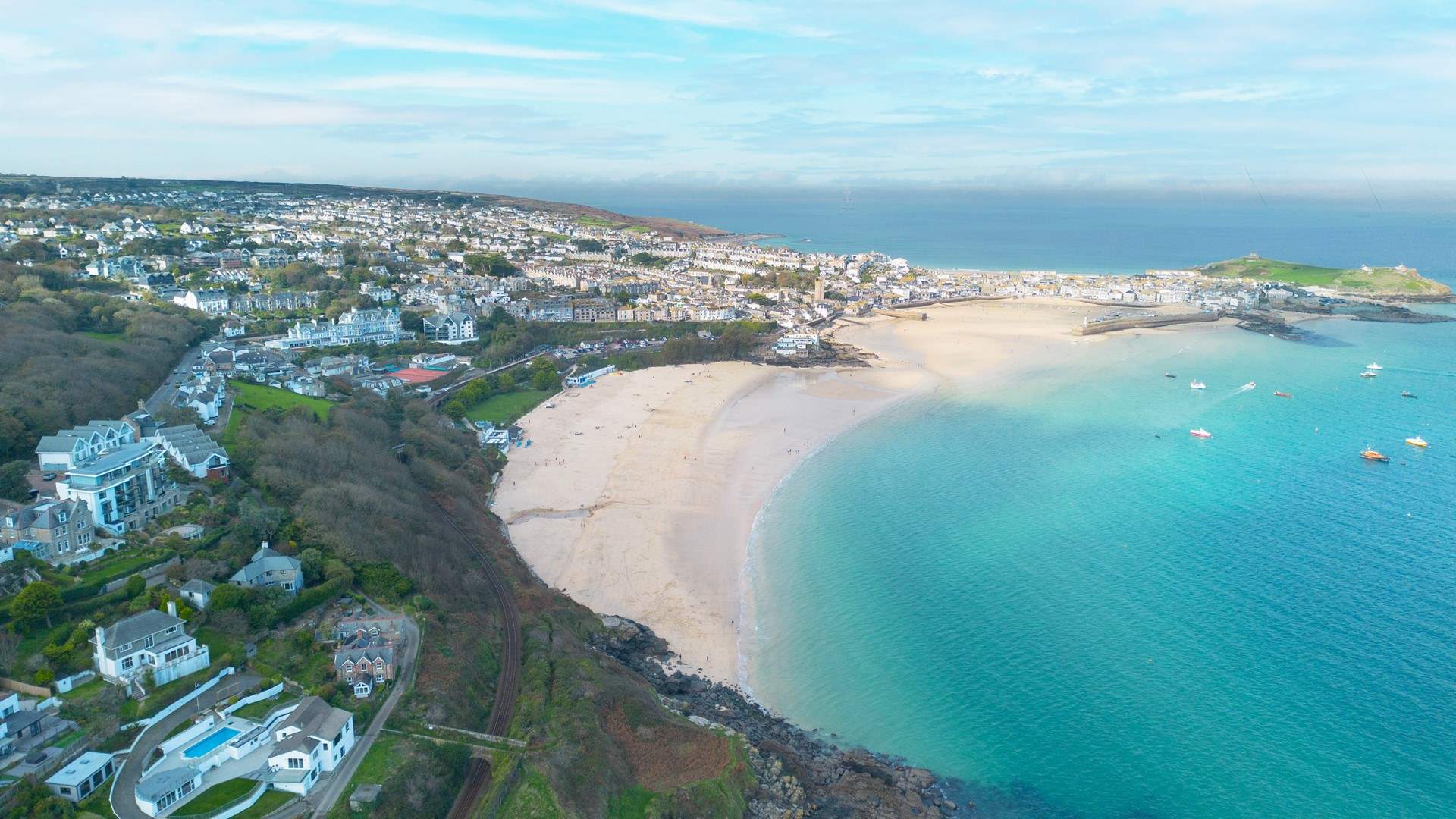Porthminster beach is admired for its natural beauty and clear waters. Morwenstow Apartments, where Spinnaker is located, can be seen to the left of the picture.