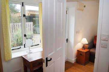 The bedroom looks out onto the private parking-area and gravel driveway to the front.