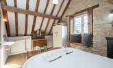 The bedroom has lovely exposed stone walls and a tall beamed ceiling. - Thumbnail Image