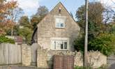 This is another view of the front of the cottage, the patio is tucked between the stone wall and the cottage, and a path leads down the side to the front door. - Thumbnail Image