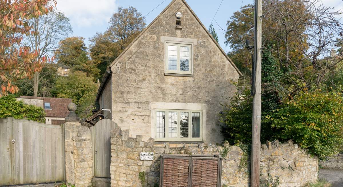 This is another view of the front of the cottage, the patio is tucked between the stone wall and the cottage, and a path leads down the side to the front door.